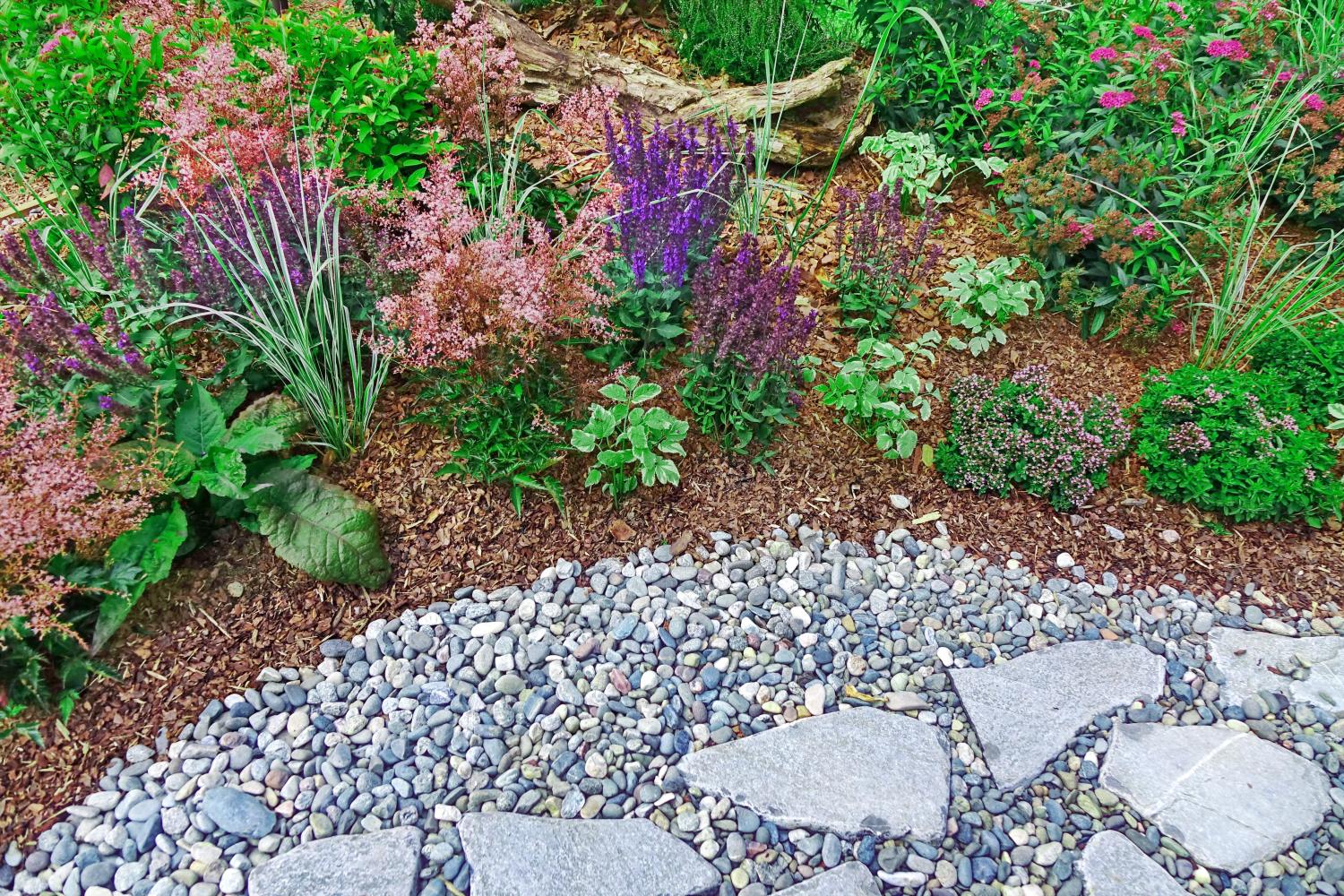 Ein kleiner Wanderweg im Garten zeigt eine kreative und stilvolle Verwendung von Steinen und Rindermulch.