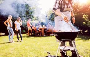 A group of friends enjoying a summer barbeque on a lawn.